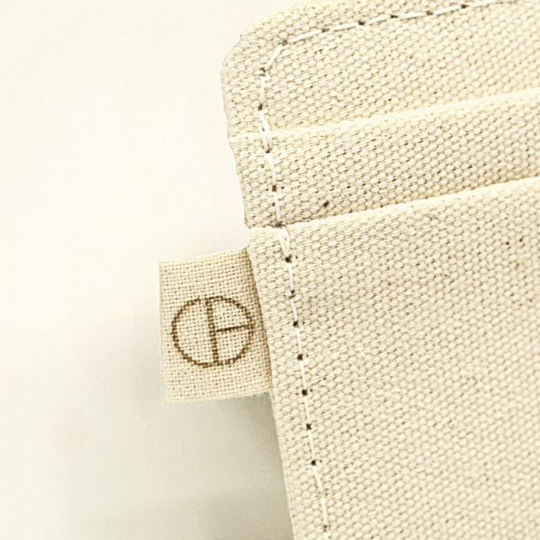 Cardholder – close-up detail by CARDHEIR – stitched canvas and laser-engraved logo tag, handmade in Amsterdam