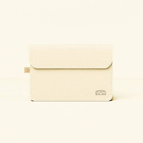 CARDHEIR bridge-inspired envelope sleeve – cream minimalist design – on desk with canal view