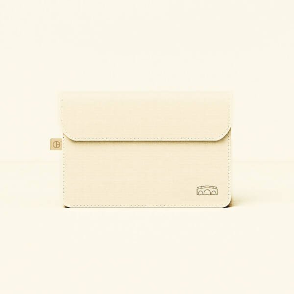 CARDHEIR bridge-inspired envelope sleeve – cream minimalist design – on desk with canal view
