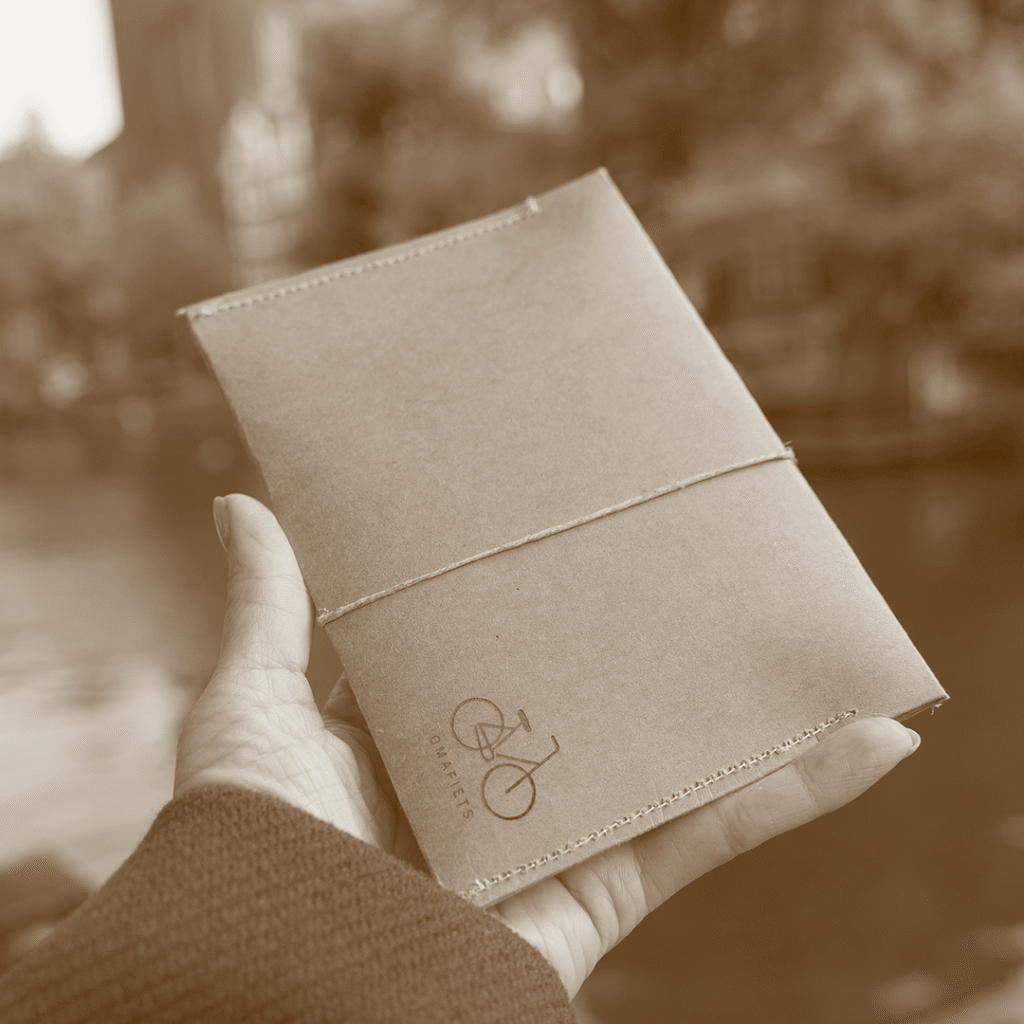 Handmade kraft envelope packaging with Omafiets bicycle icon for CARDHEIR cardholder, crafted in Amsterdam.