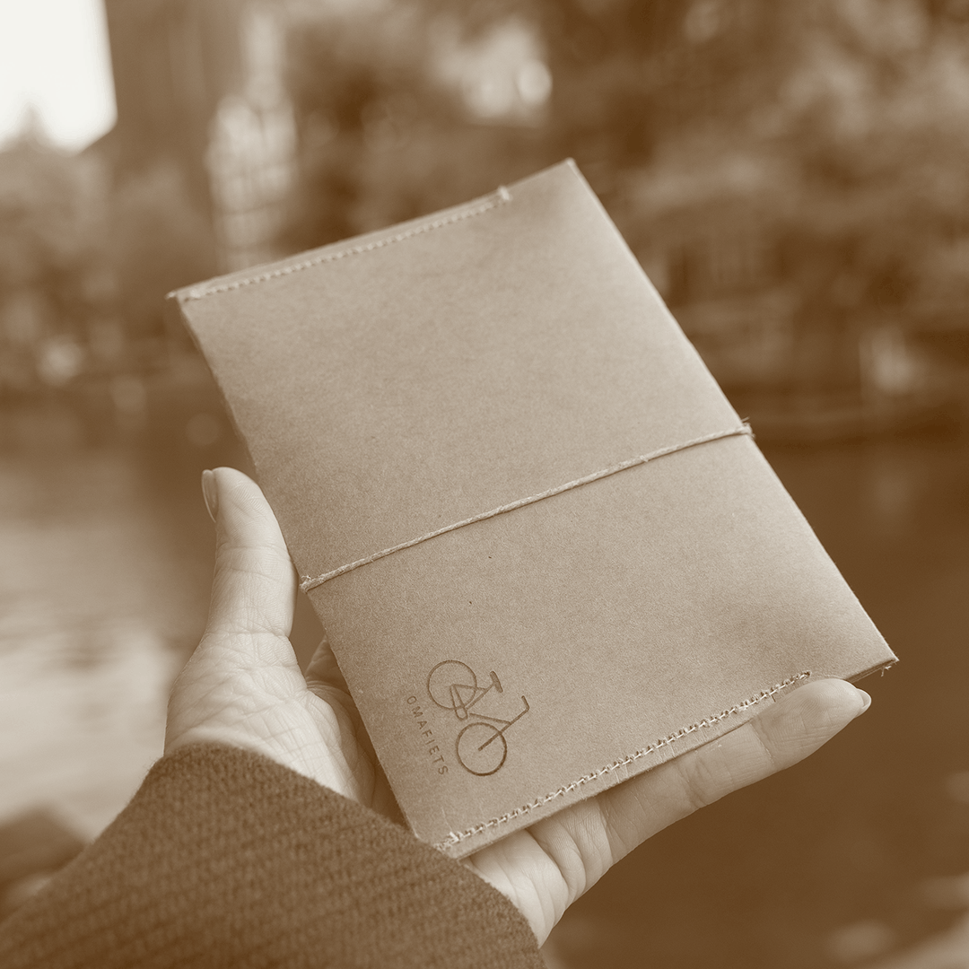 Handmade kraft envelope packaging with Omafiets bicycle icon for CARDHEIR cardholder, crafted in Amsterdam.
