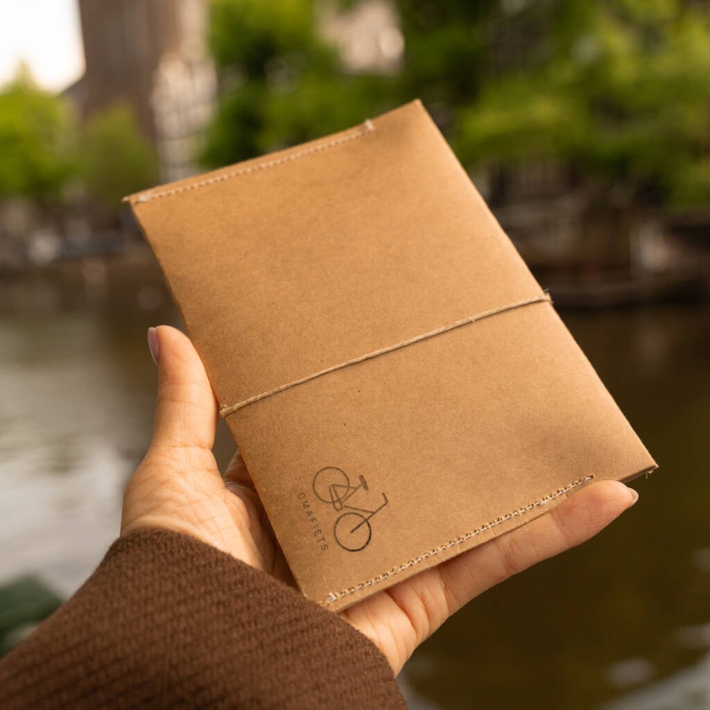 Hand holding kraft envelope with bicycle icon – Omafiets Edition – handmade CARDHEIR packaging in Amsterdam