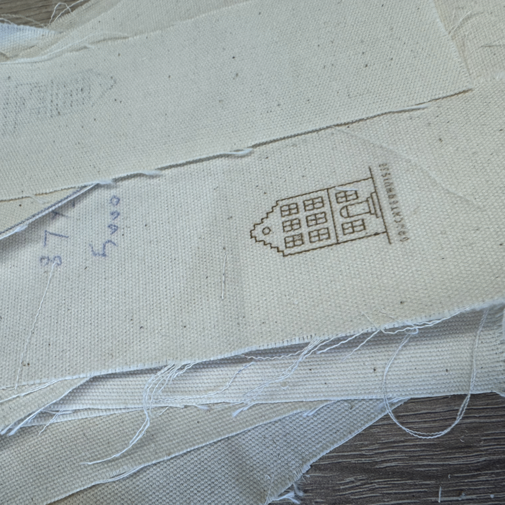 Natural cotton fabric with laser-engraved Amsterdam house design used in CARDHEIR production