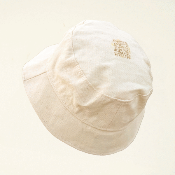 Natural undyed bucket hat with a centered laser-engraved QR code on top. A minimalist, interactive design by CARDHΞ↓R.