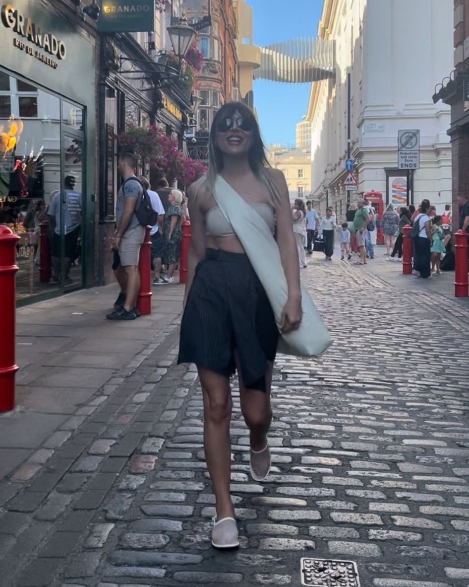 Sahar Tousi walking in London wearing a minimal chic outfit with CARDHΞ↓R handmade cardholder